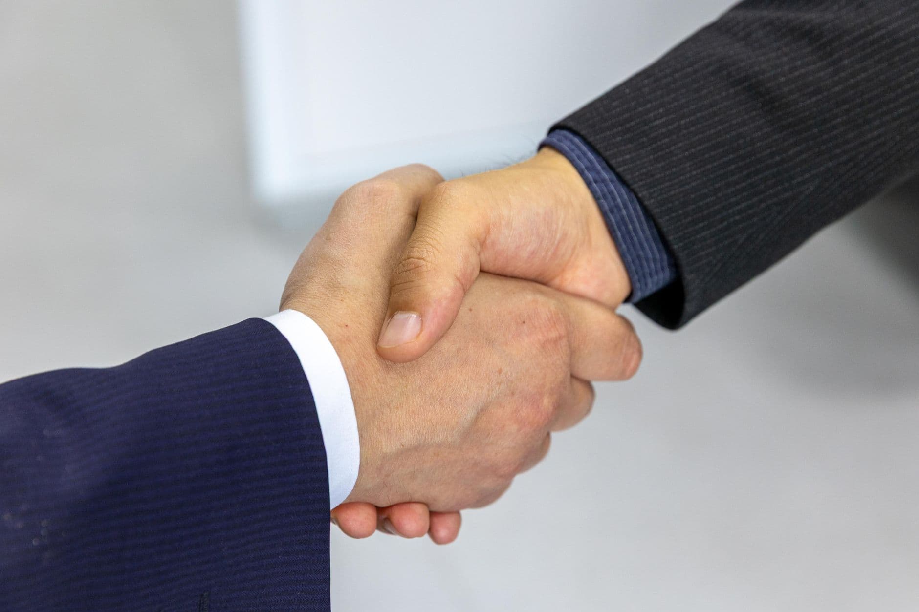 Primer plano de dos empresarios dándose la mano en señal de acuerdo.