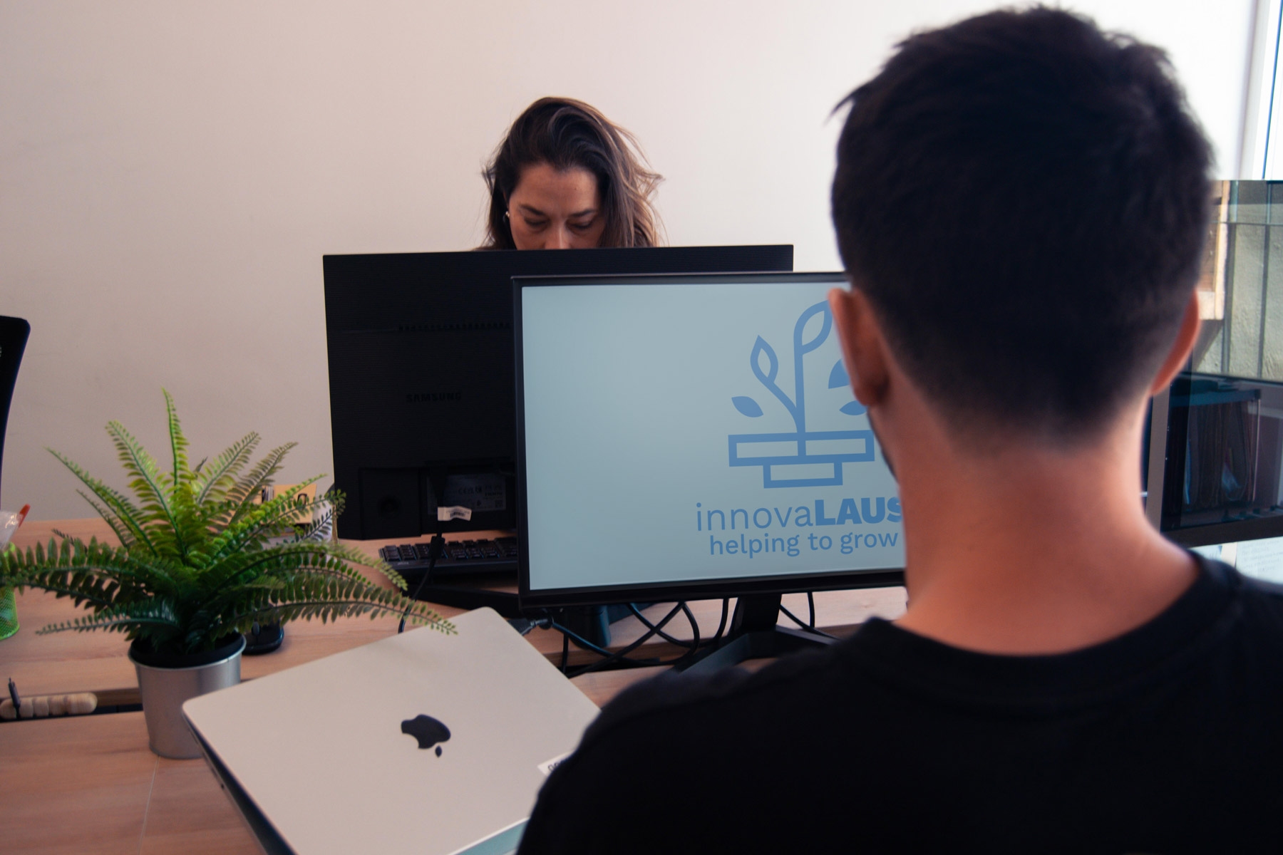 Persona de InnovaLAUS frente a una pantalla con el logo de la empresa